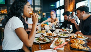 Woman eating healthy foods at restaurant with friends