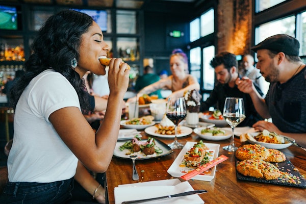 Woman eating healthy foods at restaurant with friends