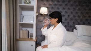 woman-drinking-water-in-bed
