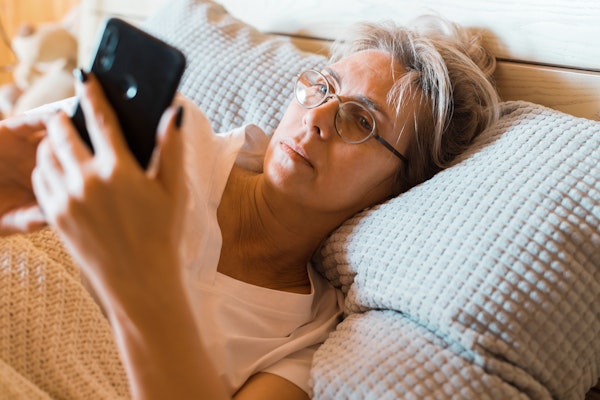 woman-looking-at-phone-in-bed