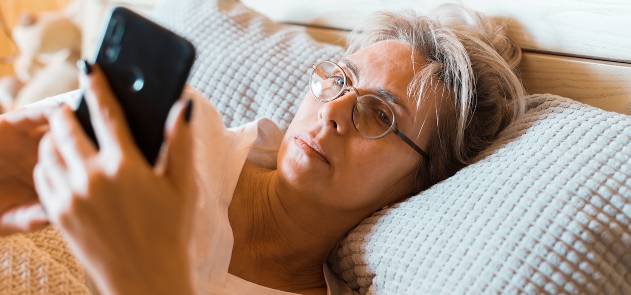 woman-looking-at-phone-in-bed