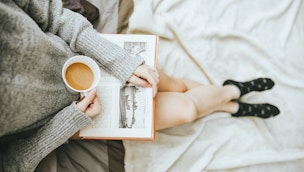 woman-holding-coffee-and-book