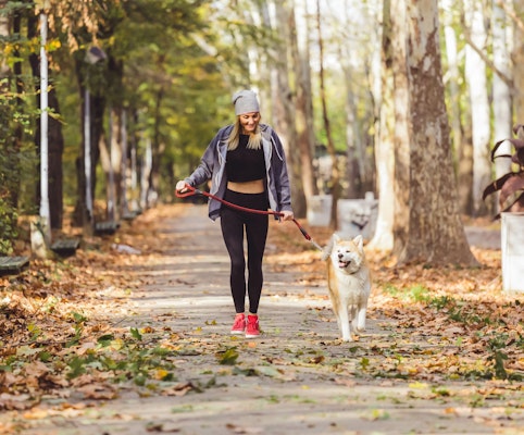 woman-walking-with-dog-in-park