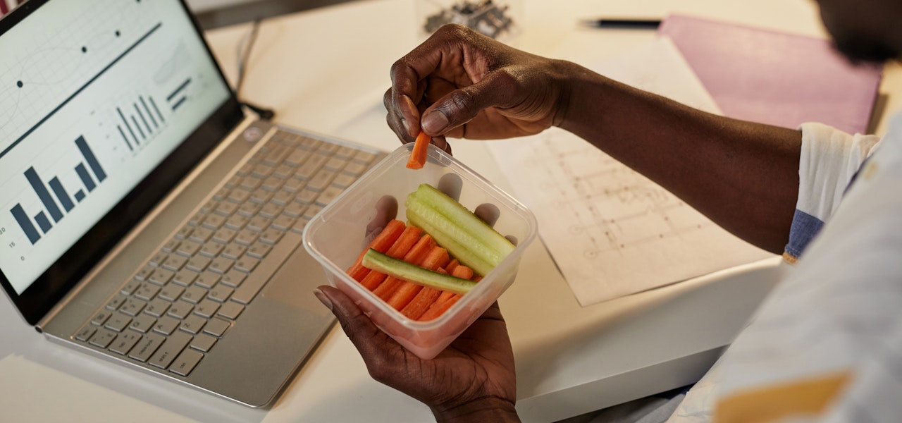 man-eating-carrot-sticks-at-his-desk