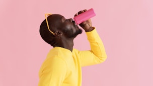 man-wearing-yellow-drinking-from-pink-can