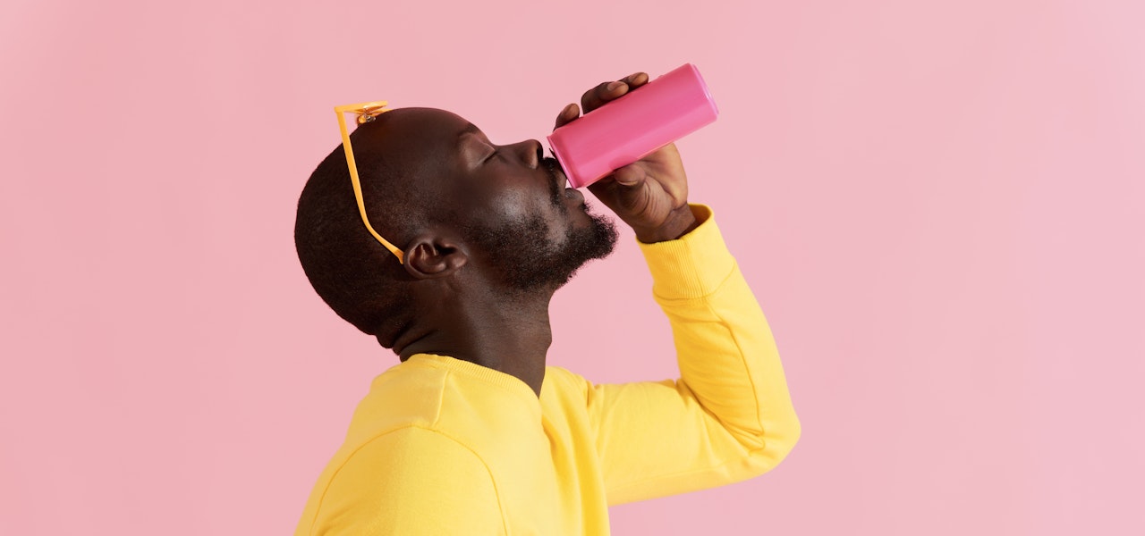 man-wearing-yellow-drinking-from-pink-can
