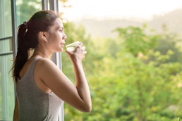 woman-drinking-water-on-balcony