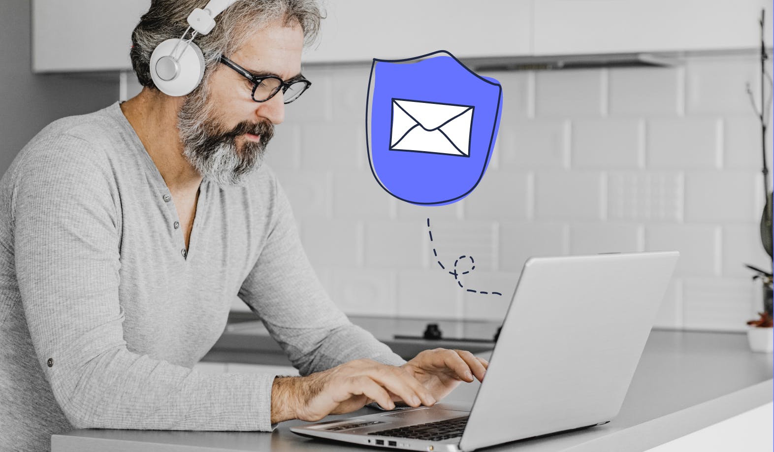 blogpost-image of a man looking at his laptop with an illustrated security shield with an email envelope inside
