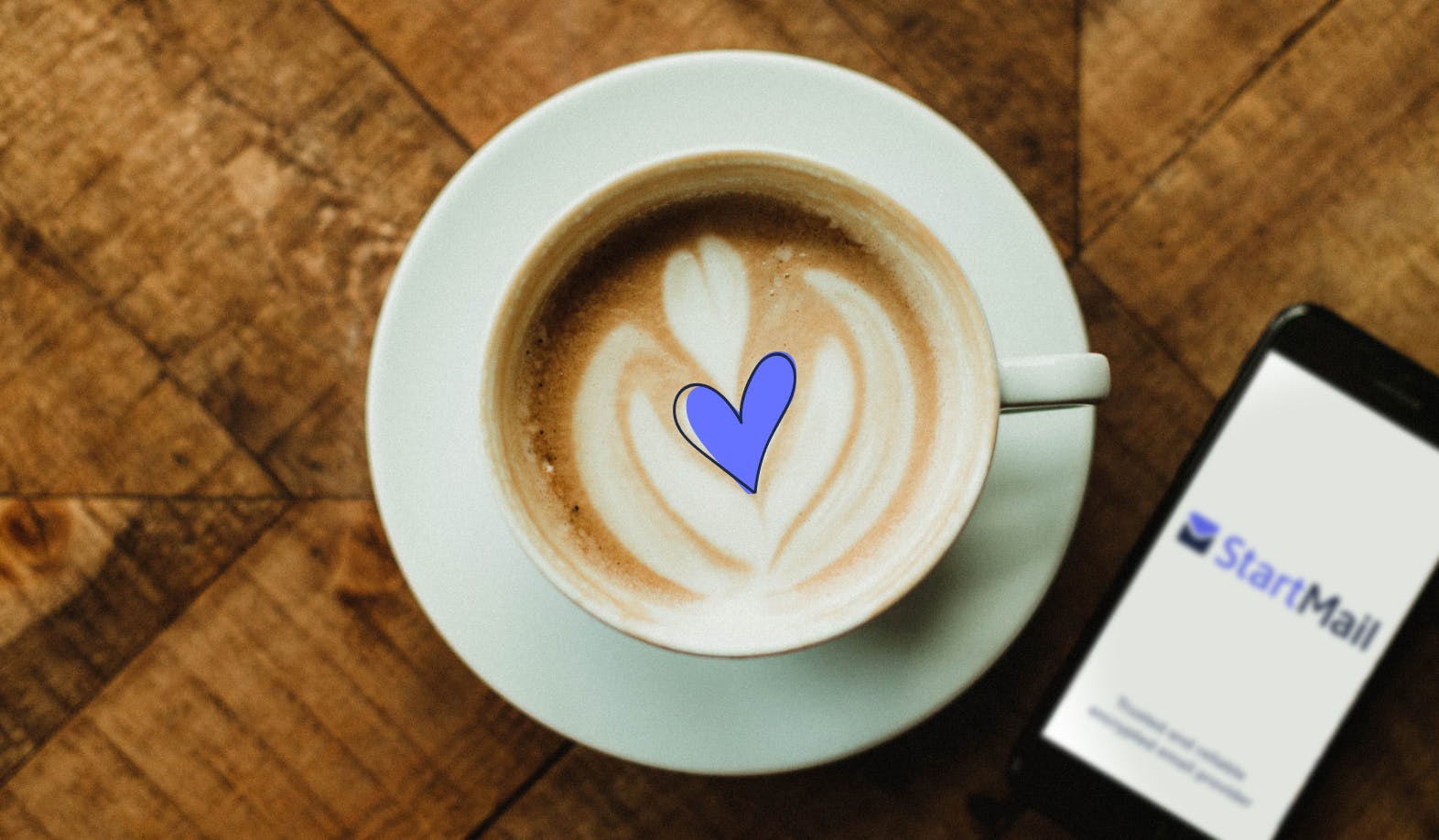 blogpost-image of a cappuccino with an illustrated heart, next to a phone displaying the StartMail logo