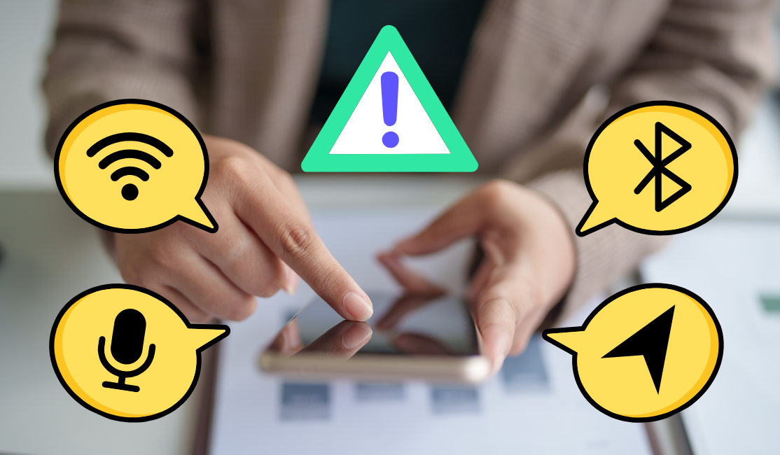 A pair of hands holds and taps on a smart phone while an animated warning icon pops up above and a series of speech bubbles with wi-fi, bluetooth, microphone, and location icons pop up on the sides of the iimage