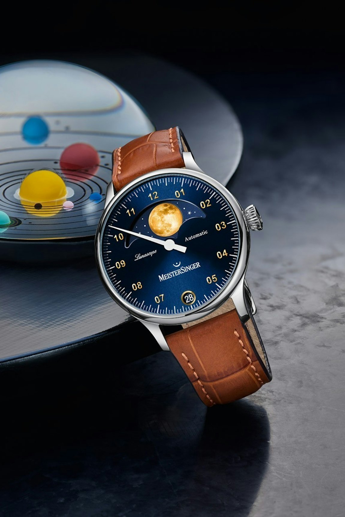 MeisterSinger Lunascope Mobil - Uhr mit blauem Zifferblatt und braunem Lederband vor dunklem Hintergrund