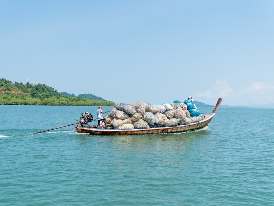 Boot mit Müllbergen aus den Weltmeeren