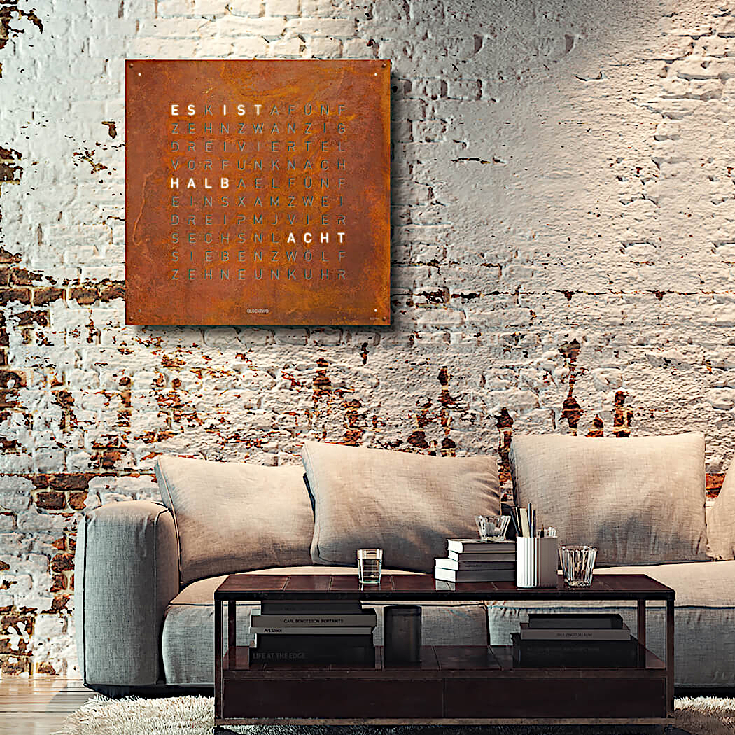 Qlocktwo Earth 90 Rust vor Ziegelwand