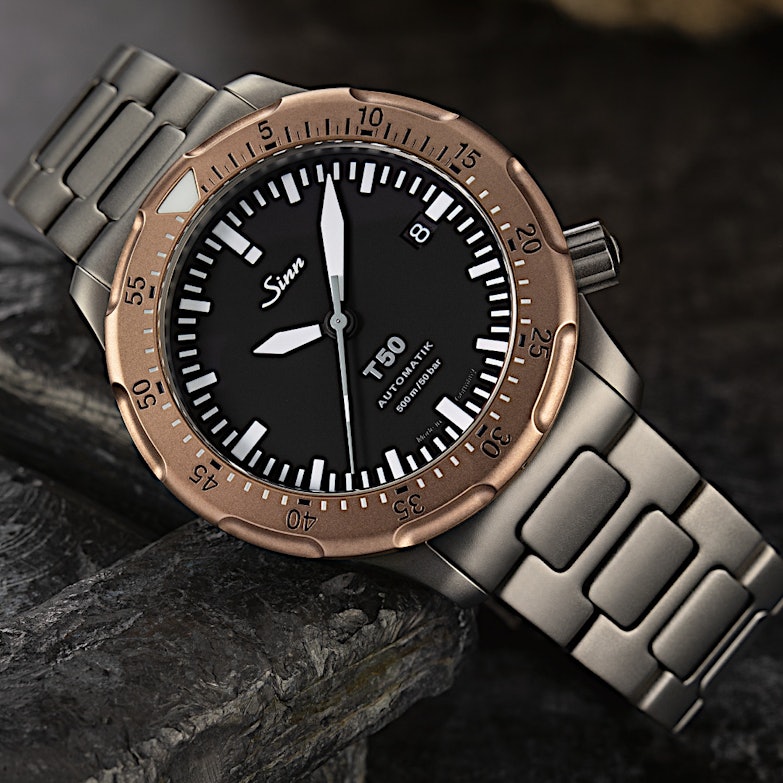 Newsgalerie Sinn T50 GBDR mit Bronze-Lünette und Stahlarmband auf dunklem Grund
