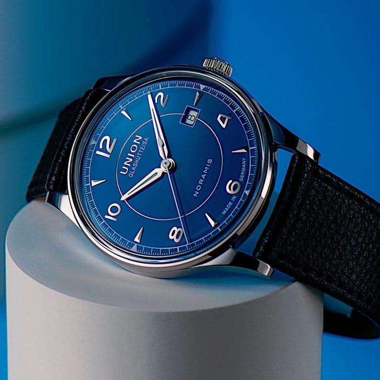 Newsgalerie Union Noramis mit Datum - das Modell mit blauem Zifferblatt auf einem Zylinder