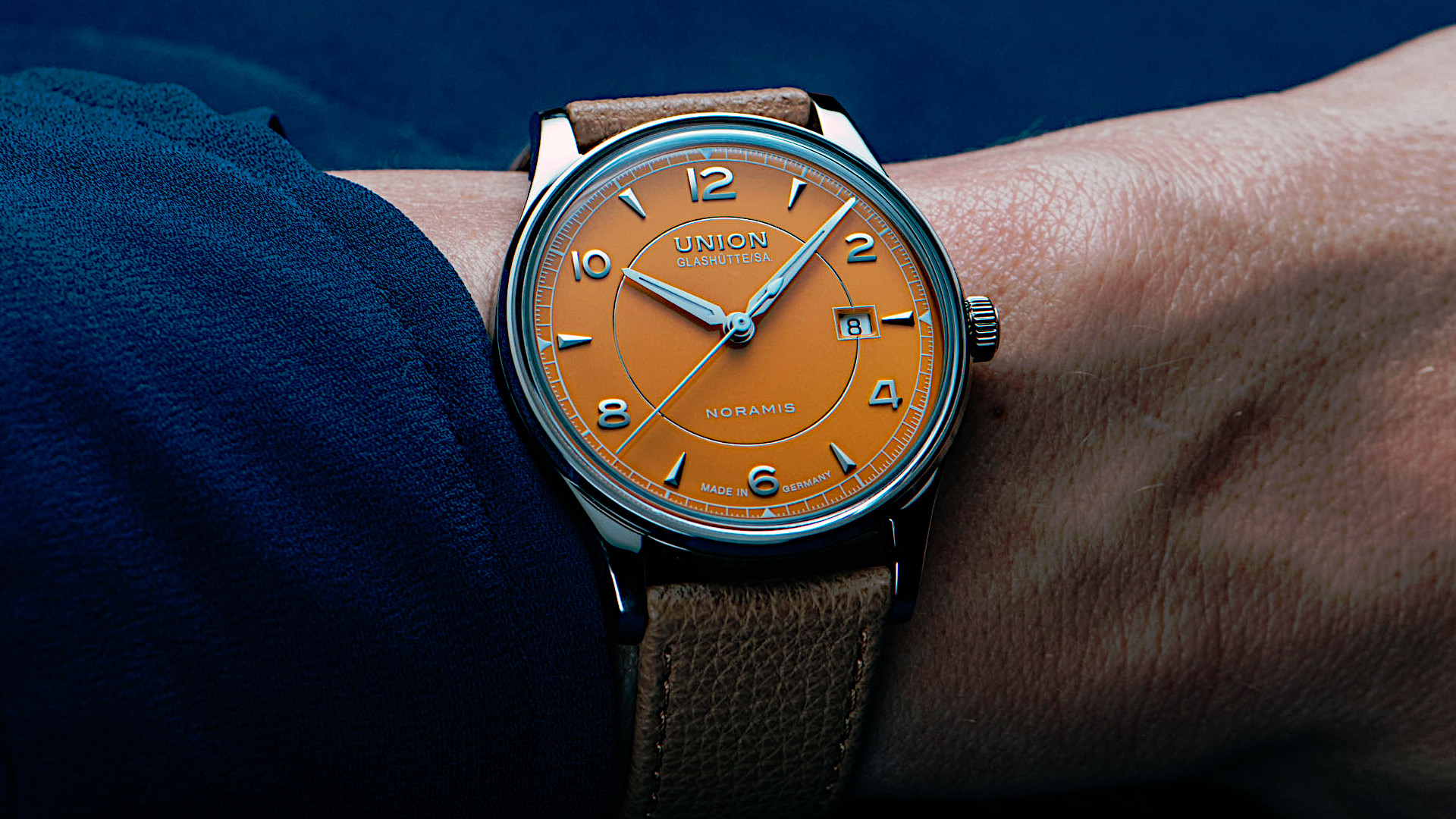 Newsgalerie Union Noramis mit Datum - das Modell mit gelbem Zifferblatt am Handgelenk einer Person