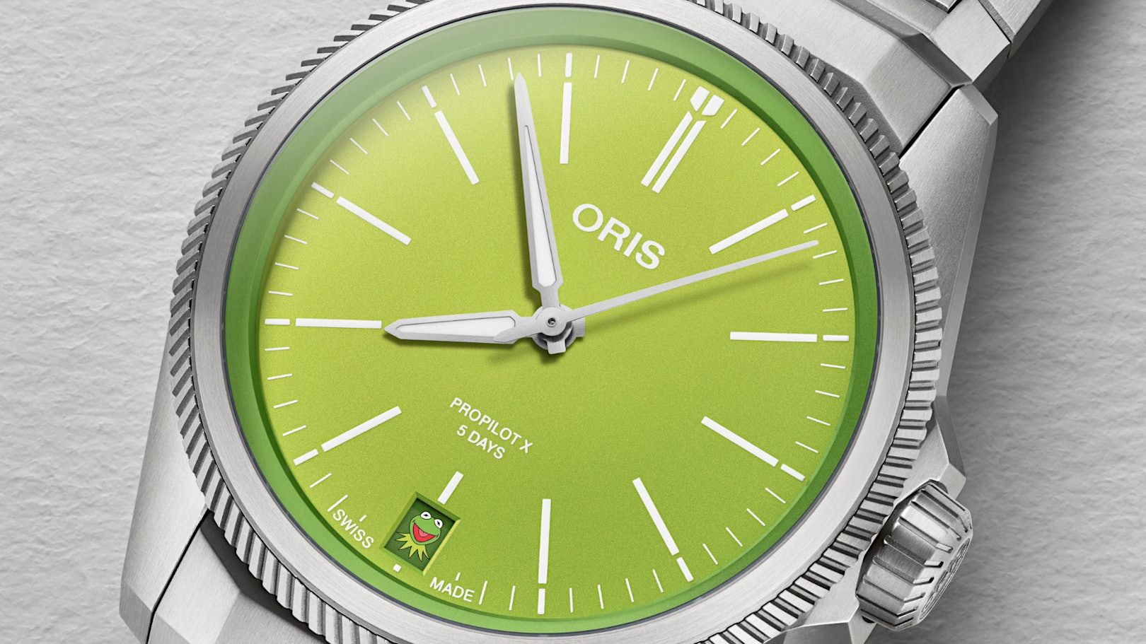Newsbild Oris ProPilot X Kermit Edition - Edelstahluhr mit grünem Zifferblatt und Kermit-Kopf beim Datum