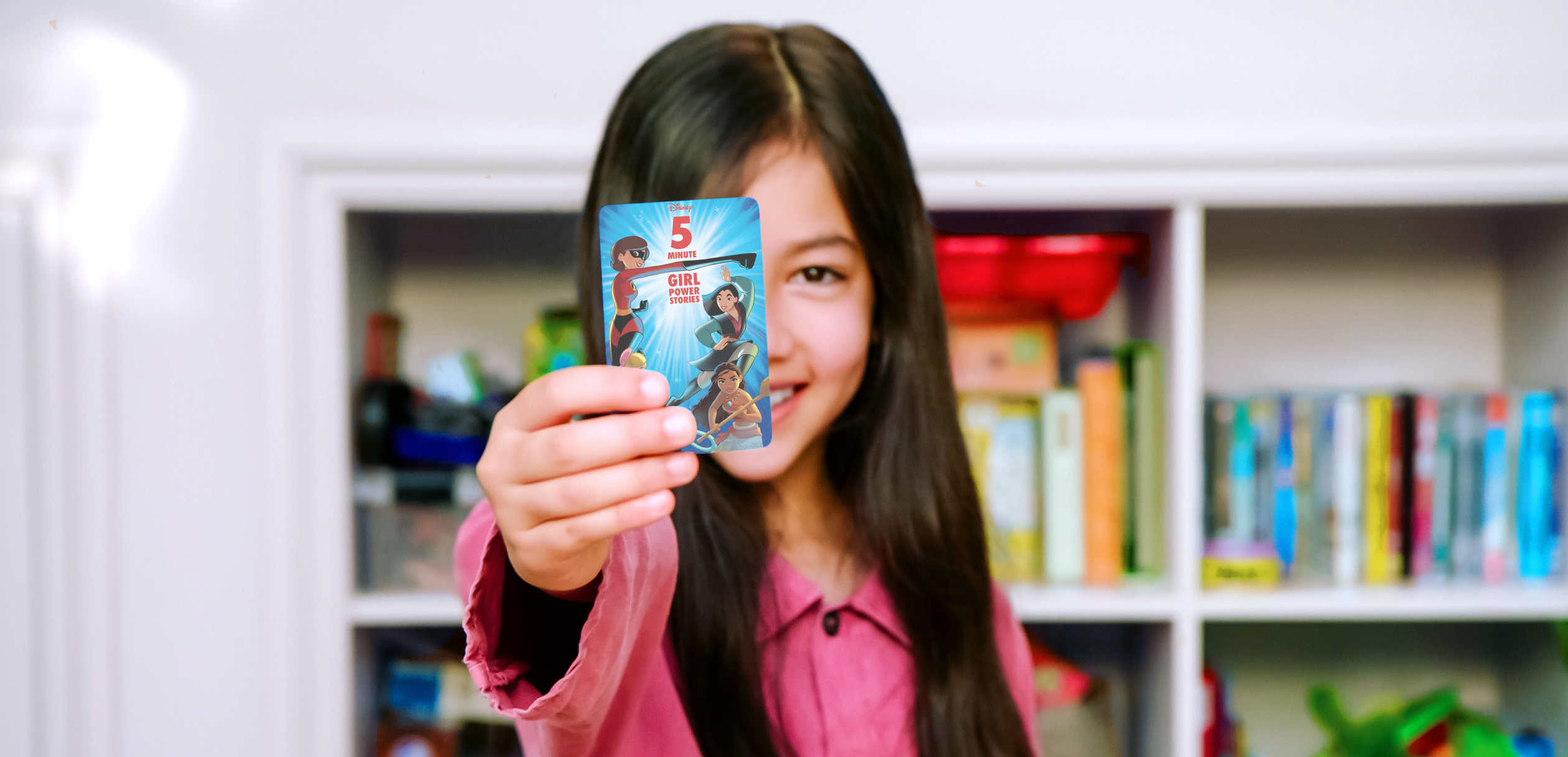 Girl holding the Disney 5 minute stories card