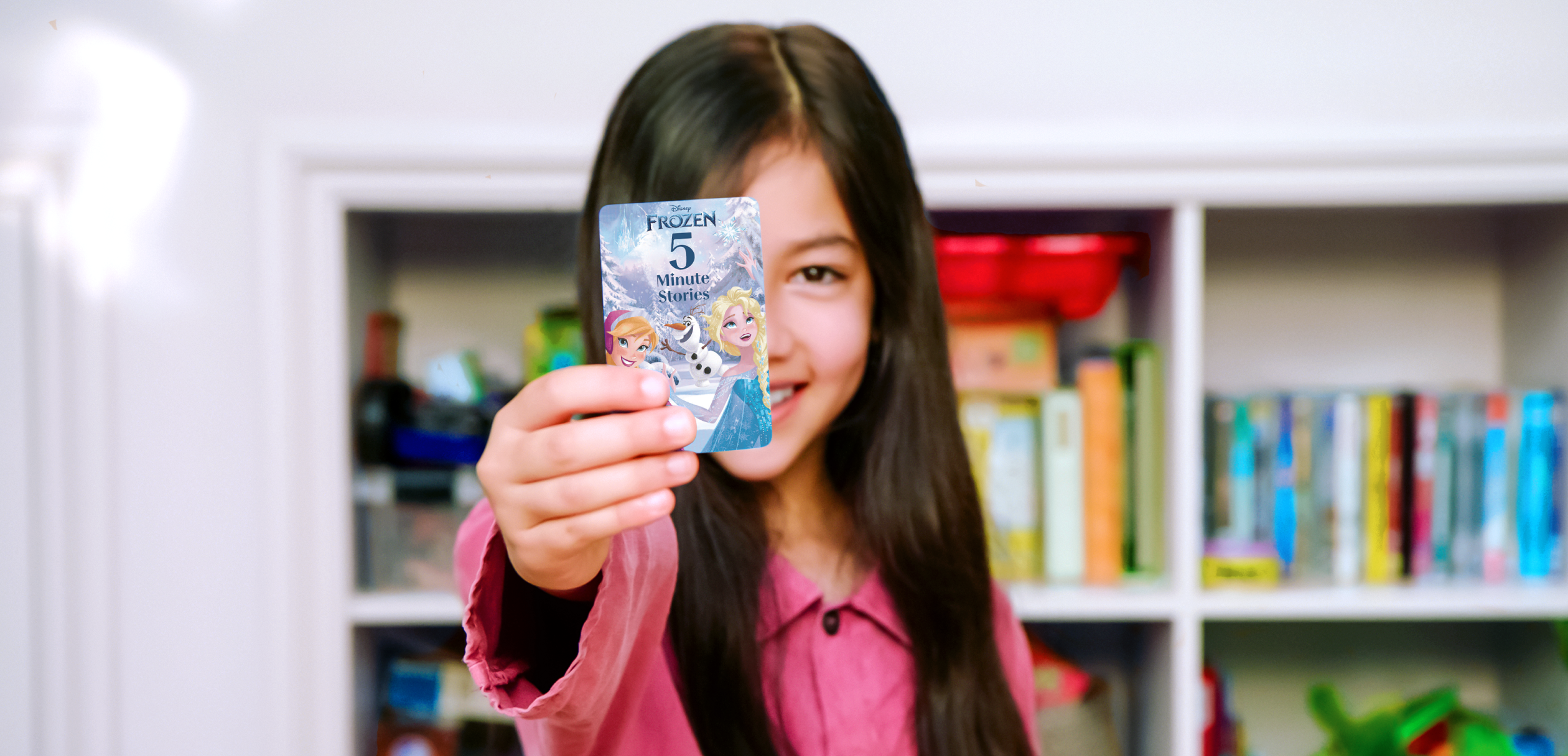 Girl holding the Disney 5 minute stories card