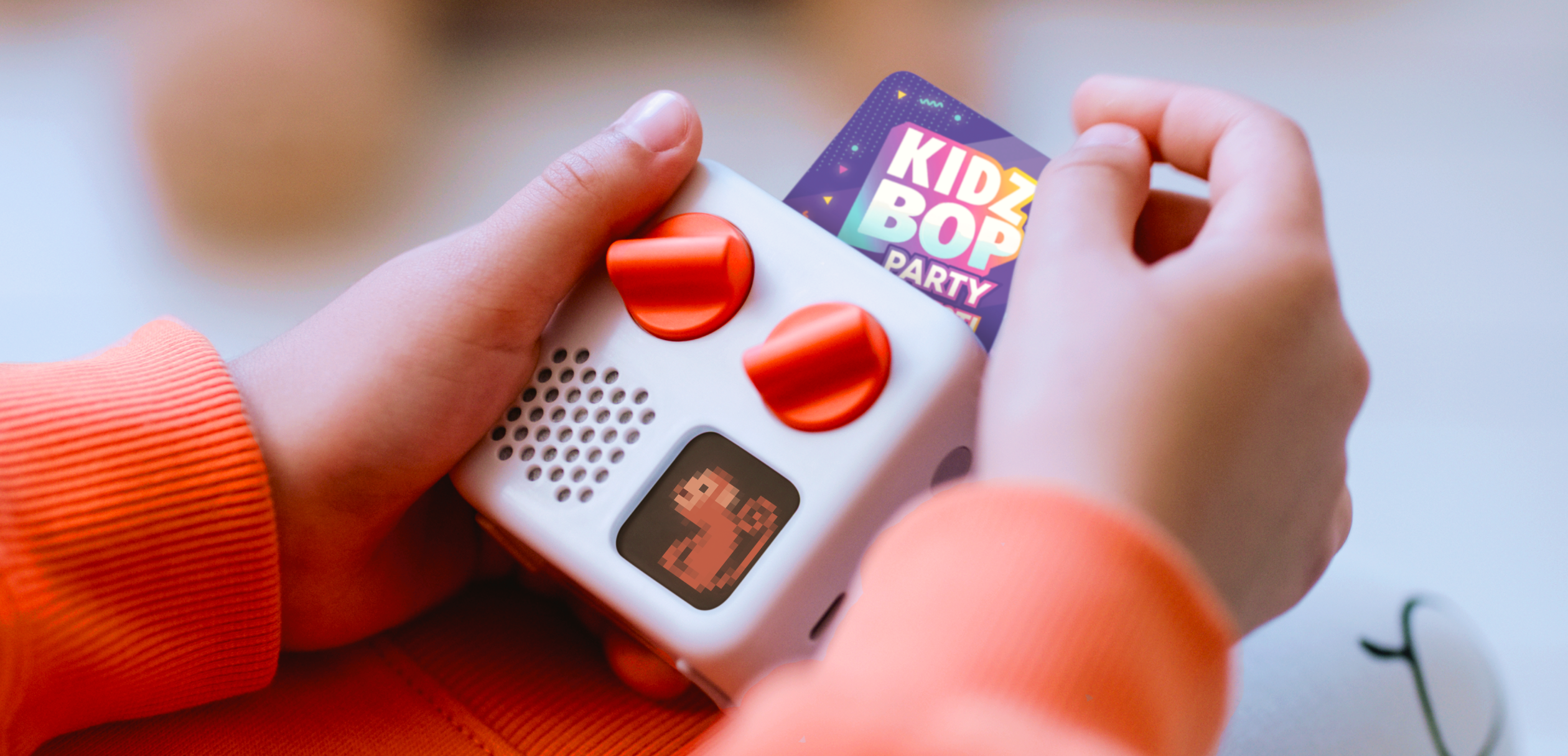 Child holding Yoto mini with Kidz Pop card inserted