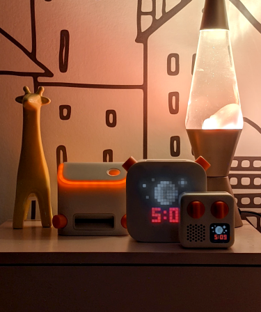 Yoto Players on bedside table at night.