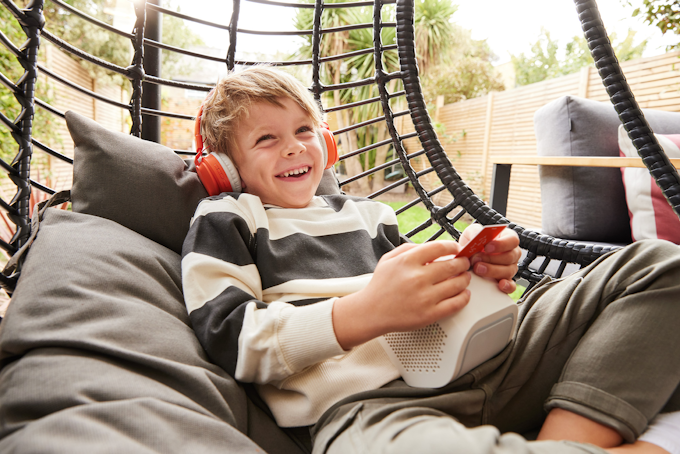 Child listening to Yoto player with headphones