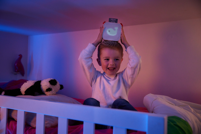 Child in bed holding Yoto Player