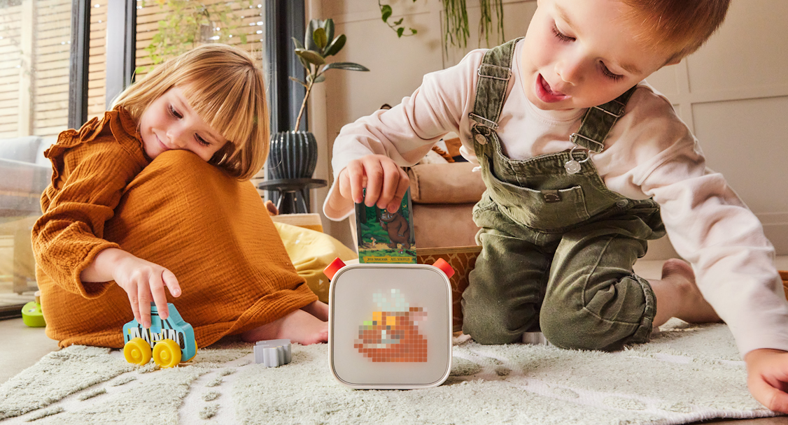 Two kids playing with a Yoto Player