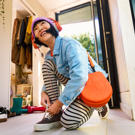 Child holding a Yoto Mini case