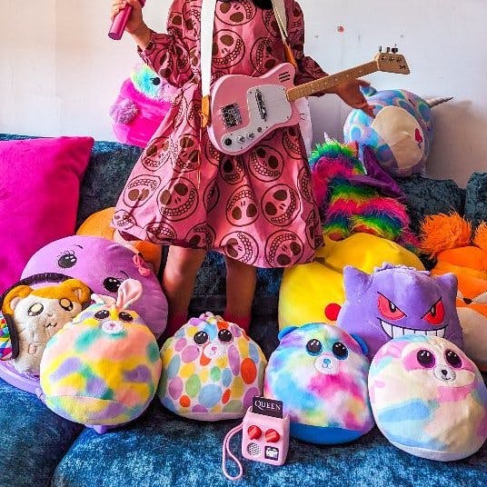 Child with toy guitar and Yoto Mini