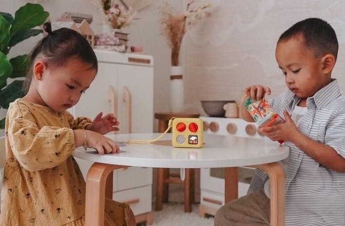 Two children at table with Yoto Mini