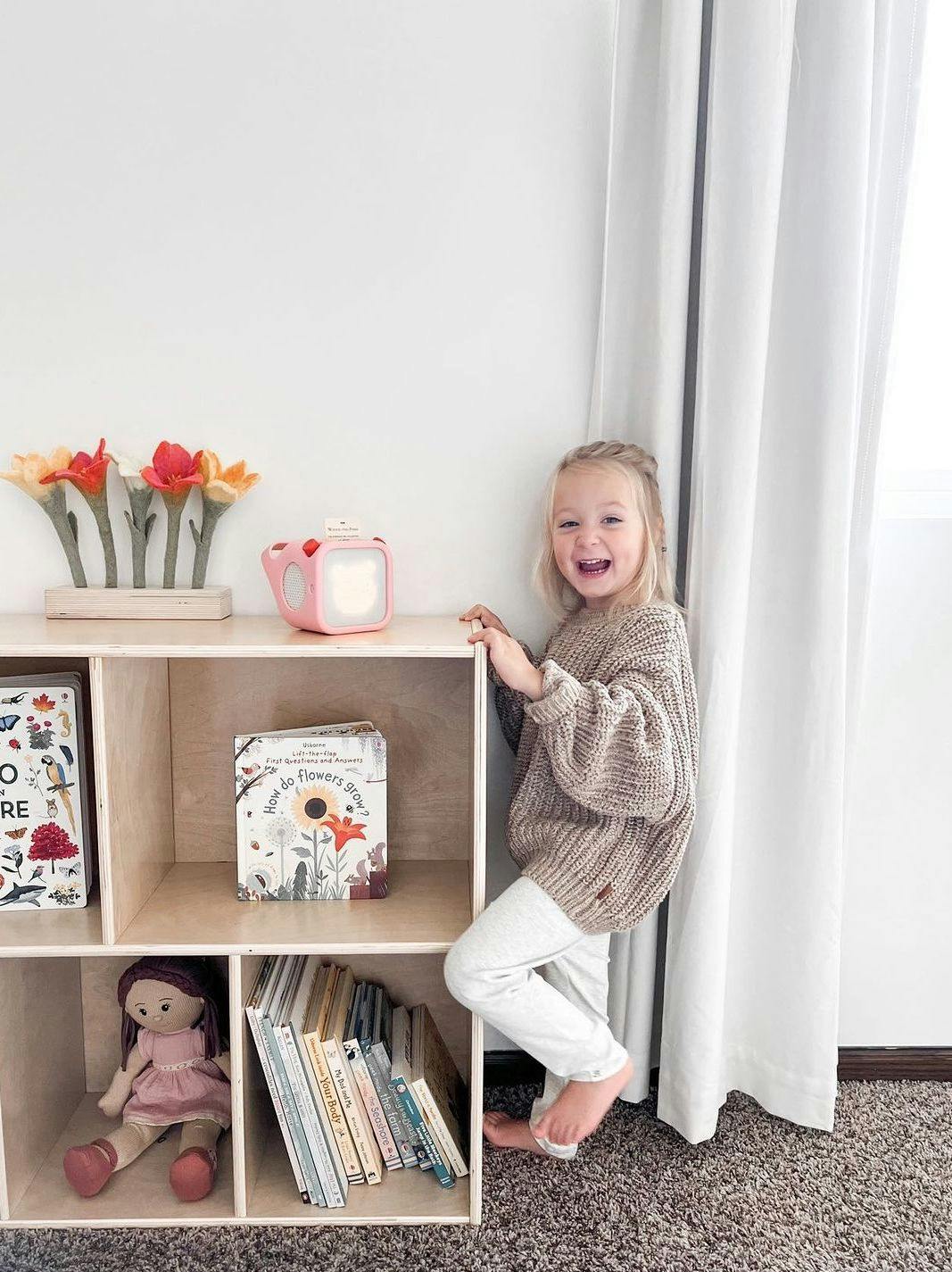 Child with Yoto Player on shelf