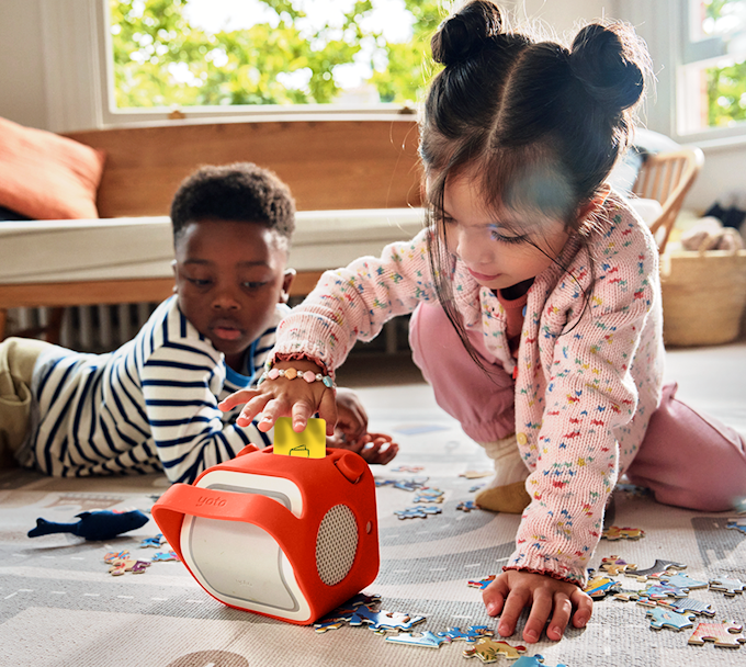 Two children playing with Yoto Player and Adventure Jacket