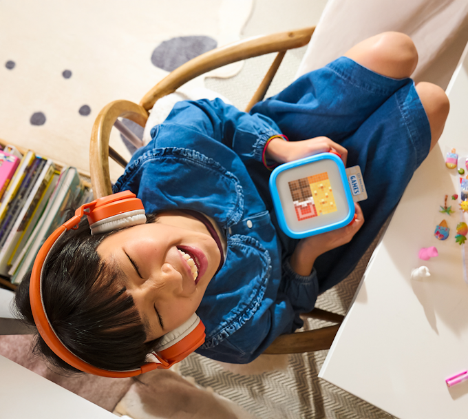 Kid playing with Yoto Player and Wireless Headphones