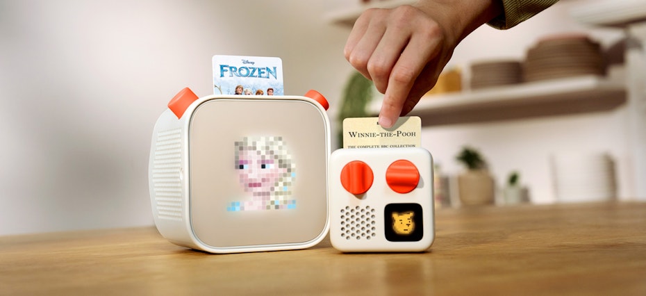 image of a yoto player and a yoto mini featuring elsa and whinnie the pooh yoto cards