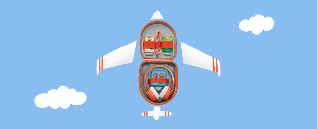 The Yoto Mini, Wireless Headphones, Charging Cable and Yoto Cards inside an open Yoto Mini Travel Case, with illustrations to make it look like an aeroplane