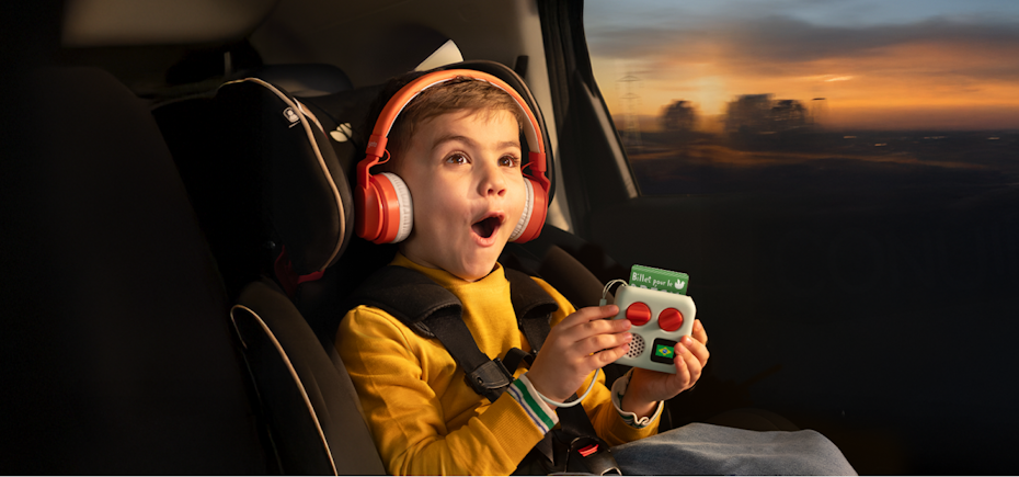 Child in carseat with yoto mini and wireless headphones