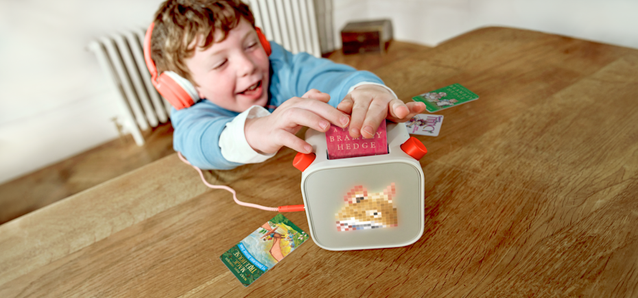 Child with a Yoto Player and Brambley Hedge card