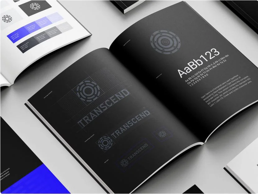 A book with black pages showcases the logo design and font of Transcend