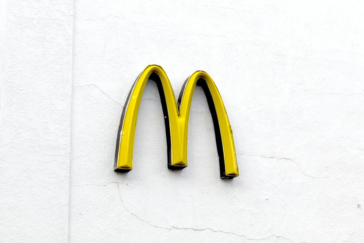 A vibrant yellow conjoined arcs against a white wall