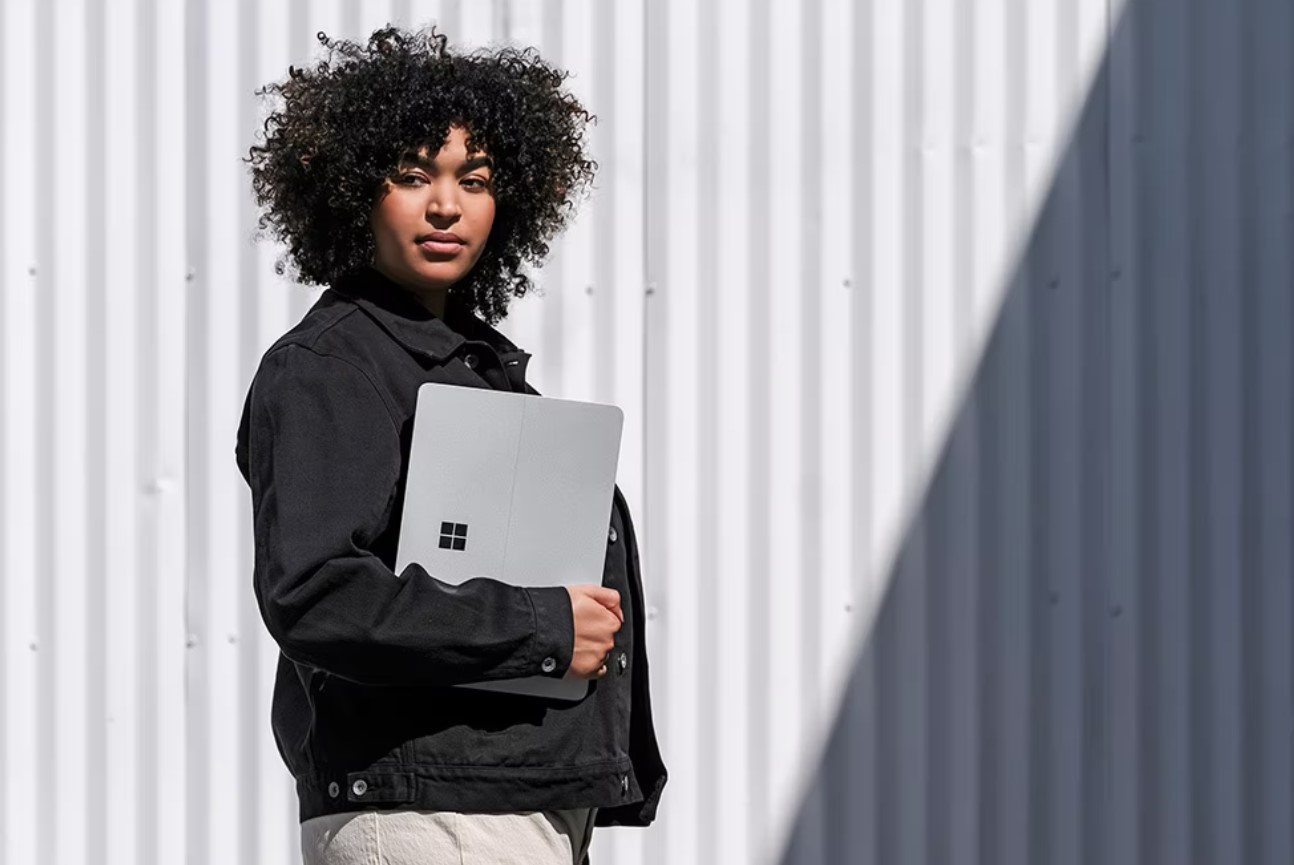 A woman holds a laptop