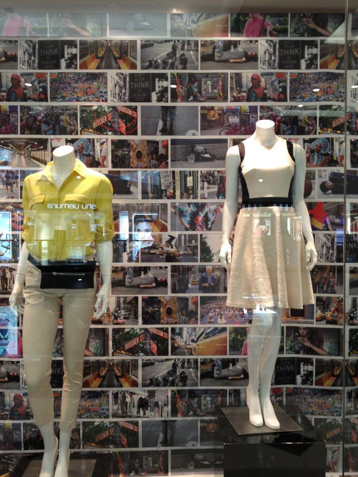 A window display with two mannequins and a gallery of images in the background