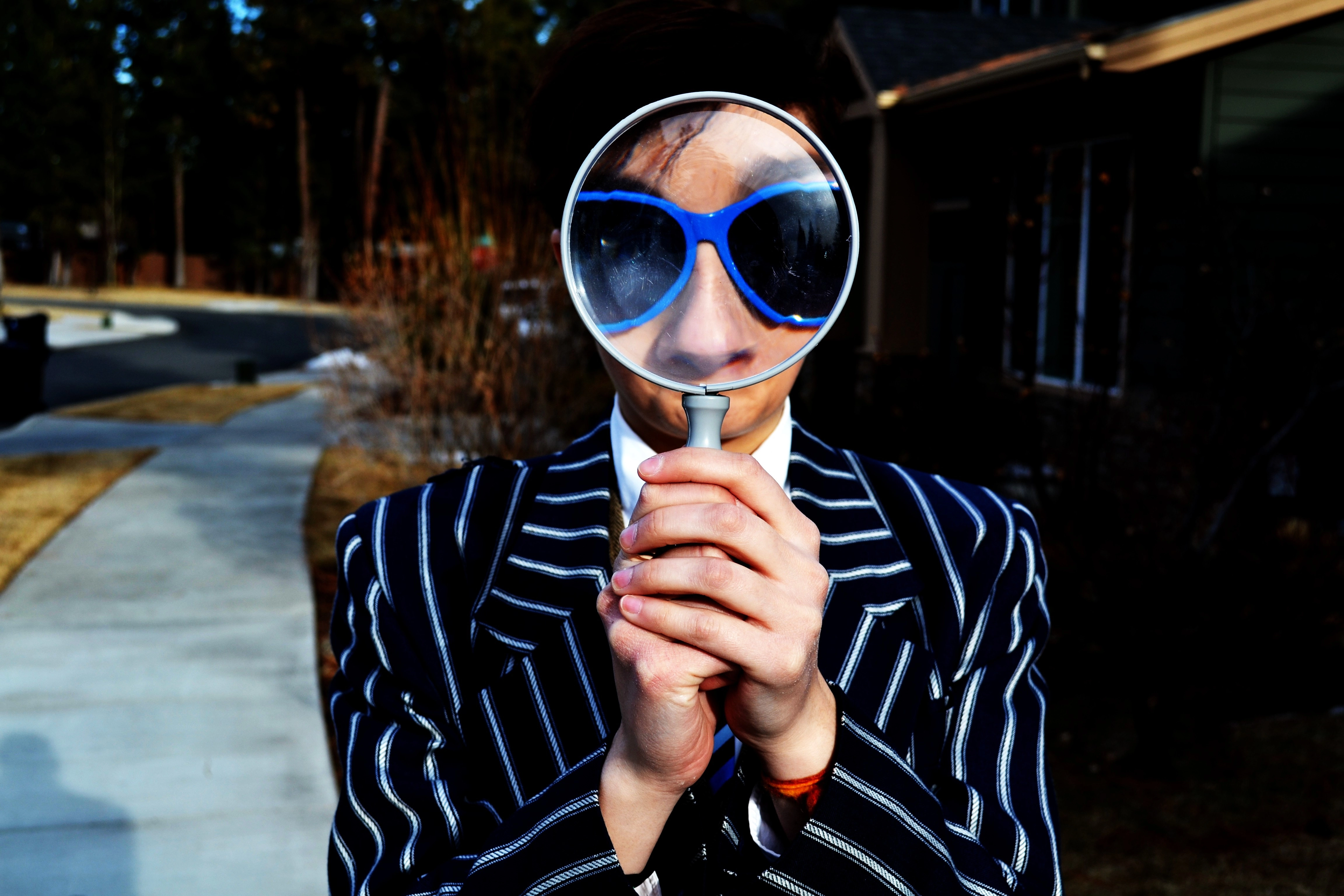 A man holds a magnifying glass in front of his face