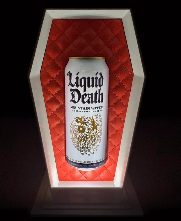 A white can with skull illustration in an open coffin