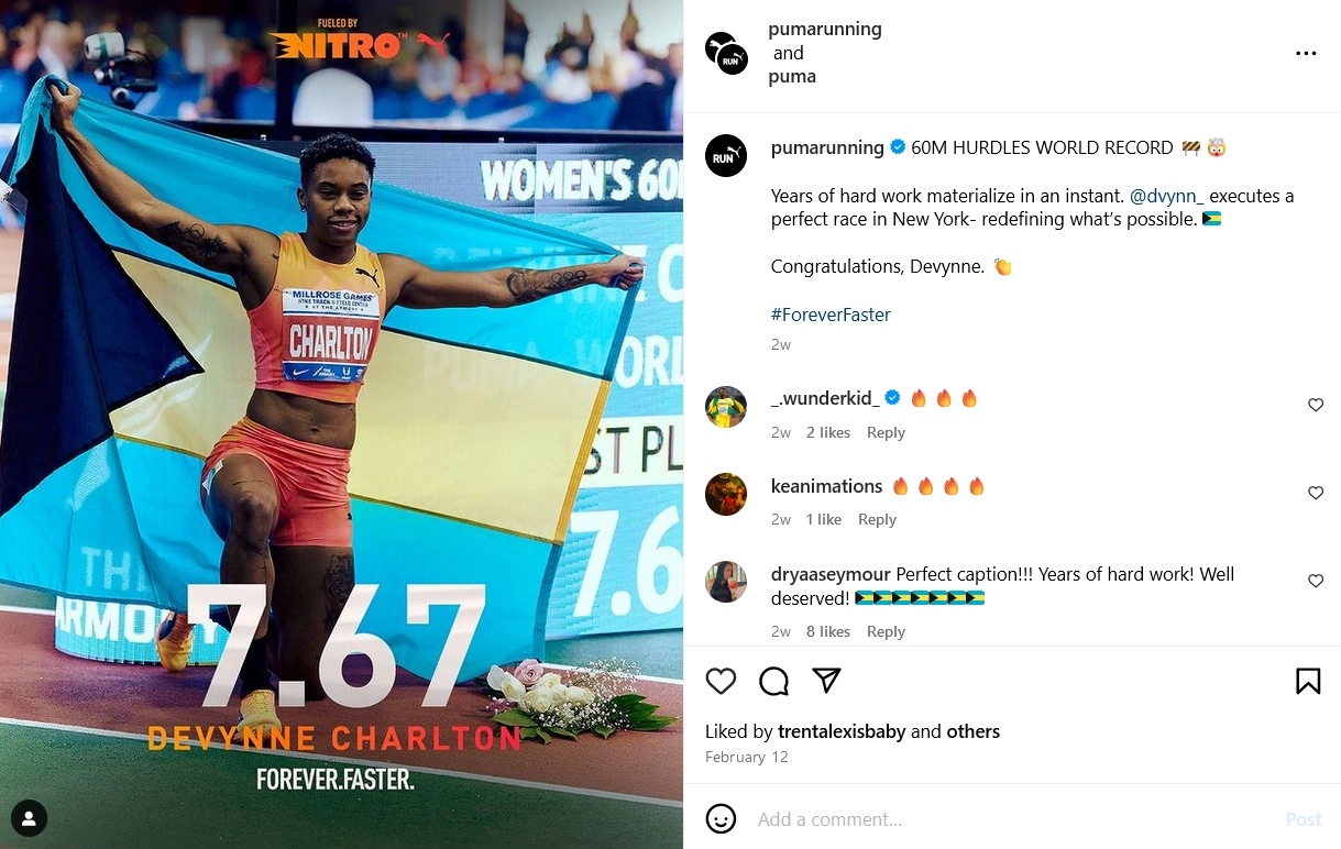 An athlete raises the blue and yellow flag of Bahamas