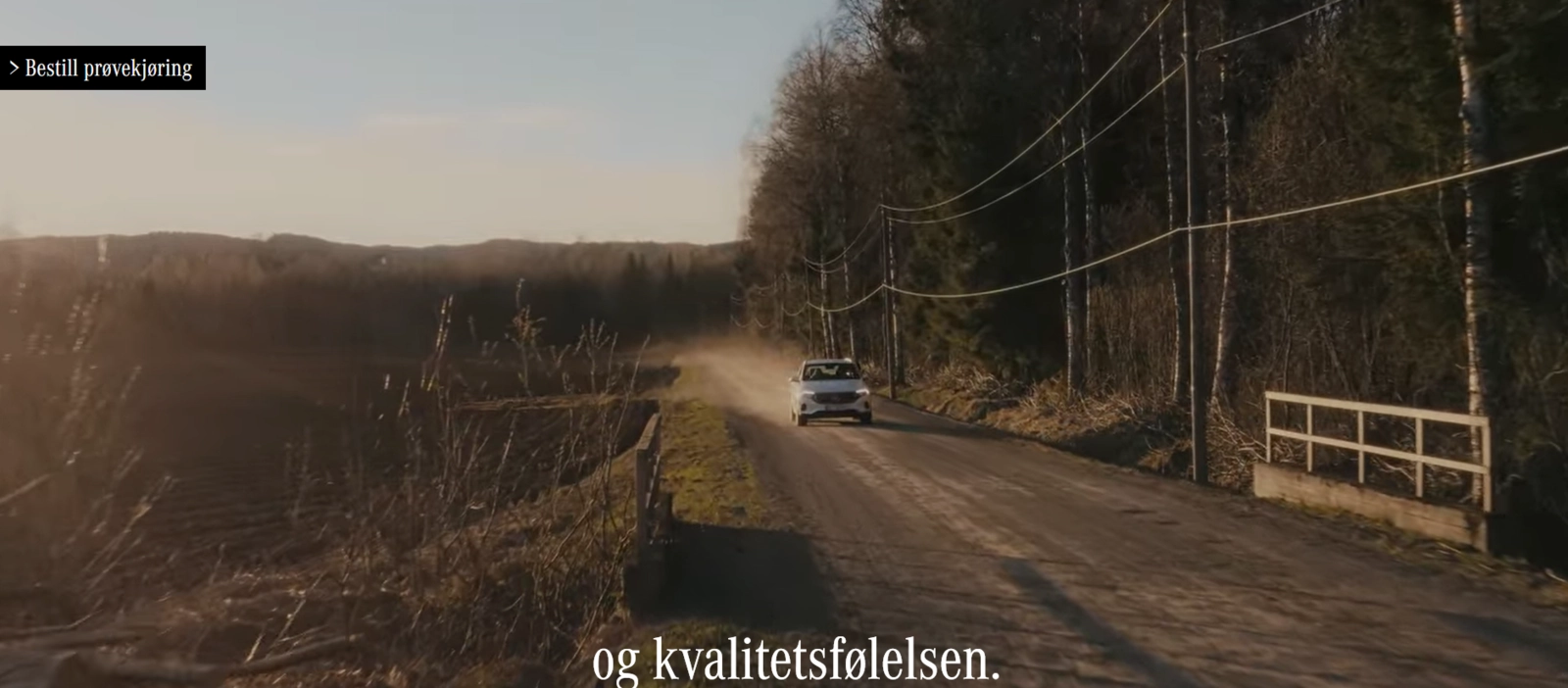 A white SUV leaves dust along its trail as it drives through a semi-rough road