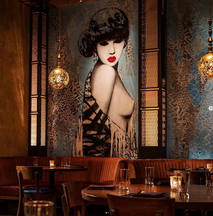 A mural of a woman with a dress draping off her shoulder