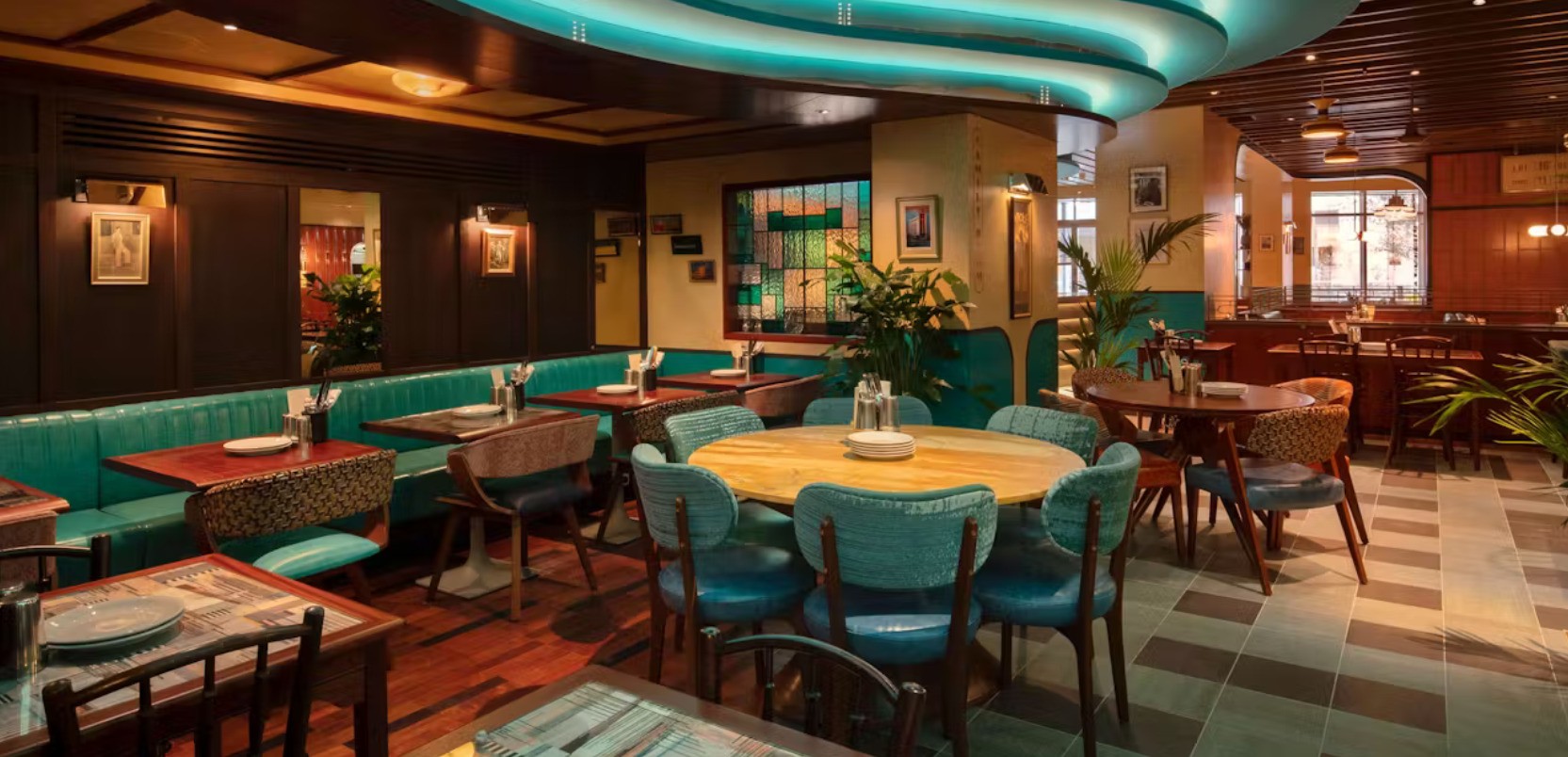 Restaurant with green upholstered chairs and wooden tables