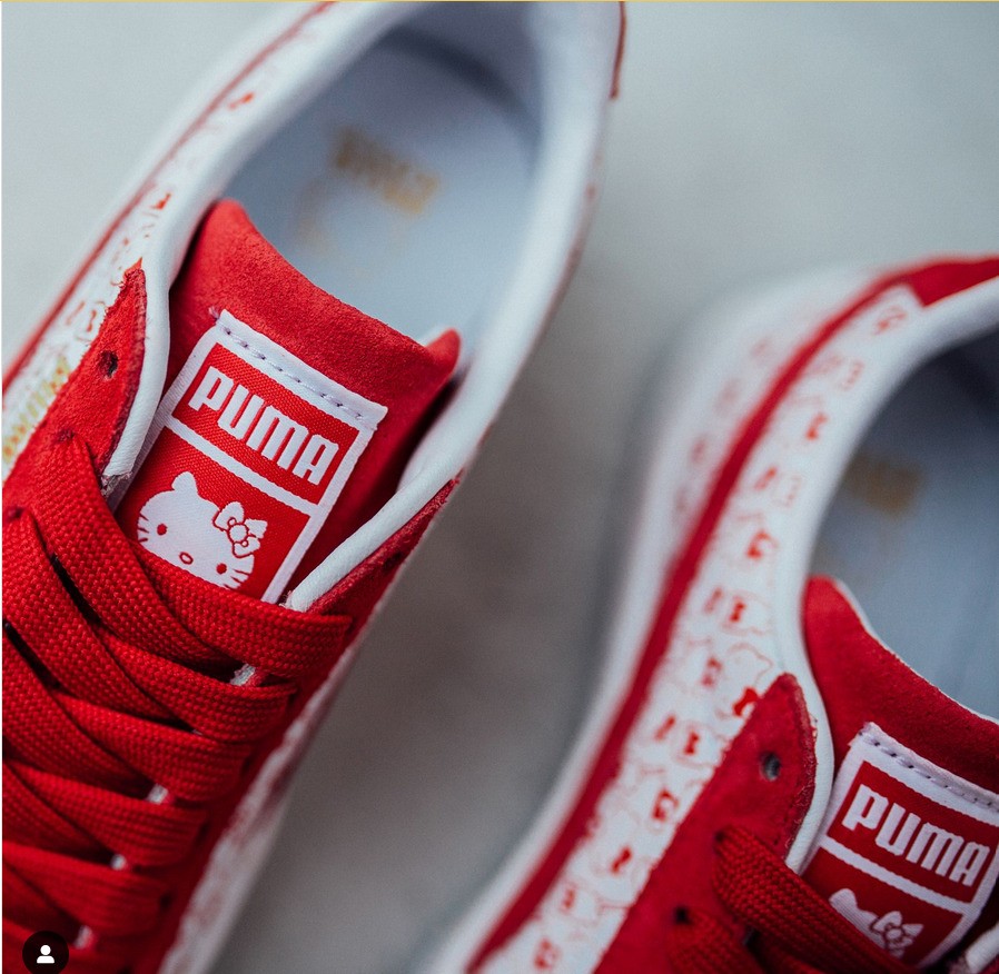 A pair of red sneakers with a Hello Kitty icon