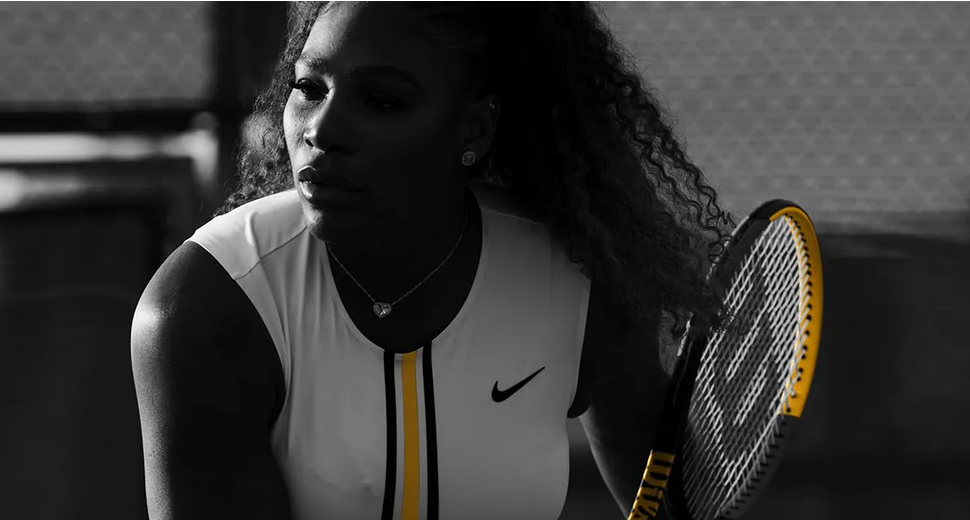 A female tennis player holds up a tennis racket